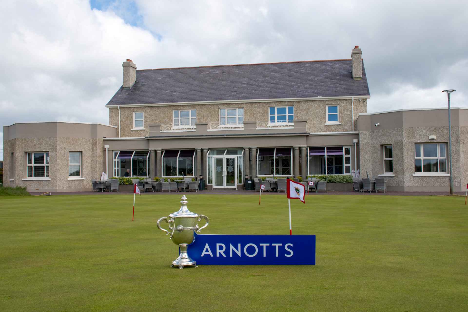 County Louth Golf Club clubhouse with East of Ireland Championship trophy and Arnotts plaque beside it